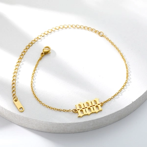 Detailed view of the 1999 year number pendant on a gold stainless steel anklet chain