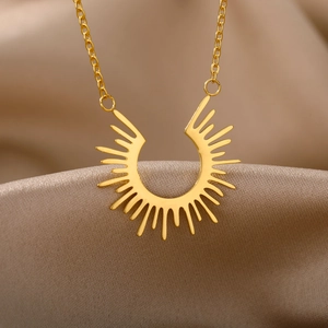 Detailansicht der goldenen geometrischen Sonnenhalskette auf elegantem Seidenhintergrund