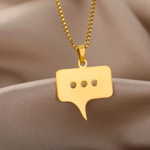 Detailansicht eines goldenen Sprechblasen-Anhängers an einer Box-Kette auf Seide