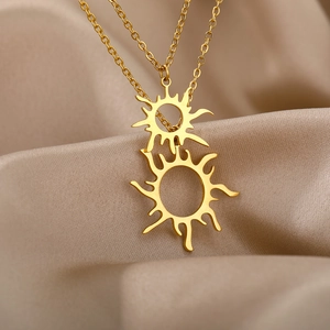 Nahaufnahme der zweilagigen goldenen Edelstahlkette mit Sonnenanhängern auf Seide