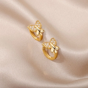 Detail von Schmetterling-Ohrringen mit Zirkonia auf champagnerfarbenem Satin