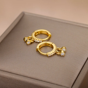 Makroaufnahme von 18k vergoldeten Creolen mit Zirkonia und hängenden runden Anhängern