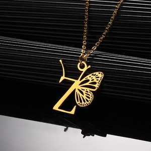 Detailopname van een gouden vlindervleugel met letter Z-hanger aan een verfijnde ketting
