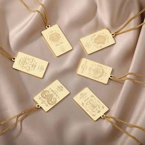 Detalle de seis colgantes rectangulares del zodiaco en oro sobre seda satinada champán