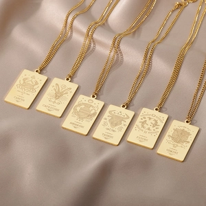 Detalle de collares del zodiaco en oro de 18K sobre elegante tela de seda champán