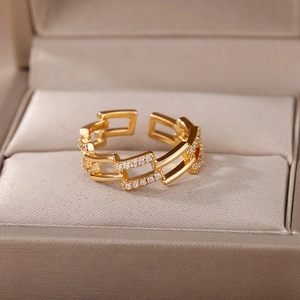 Anello geometrico multistrato dorato con zirconi pavé in una scatola portagioie di lusso