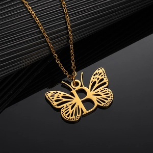 Macro shot of gold stainless steel butterfly pendant with hollow wing and letter B detail