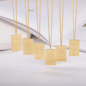 Detalle de colgantes rectangulares de oro de 18K con grabados de los signos del zodíaco