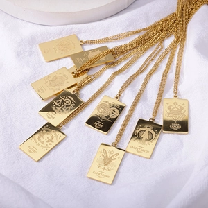 Detalle de los colgantes del zodiaco bañados en oro de 18K sobre fondo de tela blanca