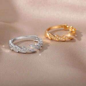 Dettaglio degli anelli a saetta in oro e argento con micro-pavé di zirconi cubici
