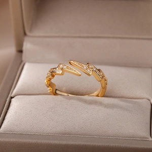 Dettagli dell'anello a fulmine dorato con intarsio di zirconi brillanti in una scatola