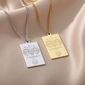 Detalle de collares con colgante rectangular del signo Aries en plata y oro sobre seda