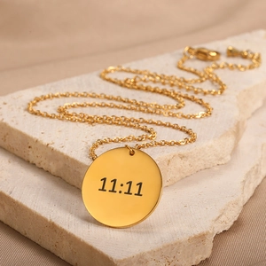 Detailed view of gold stainless steel circular pendant engraved with 11:11 angel numbers