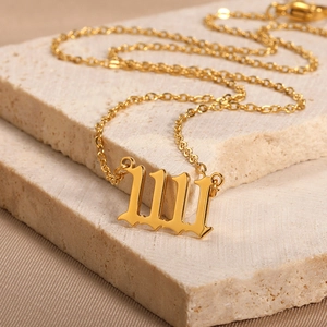 Detail view of 18K gold plated heart pendant with gothic number 111 engraving on stone