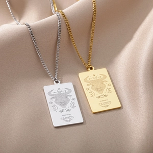 Detalle de los collares con colgante del zodiaco Tauro en oro y plata sobre seda fina