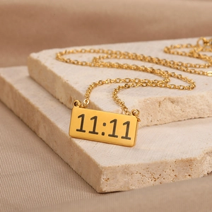 Detail shot of 18K gold plated rectangular pendant with 11:11 engraving on steel chain