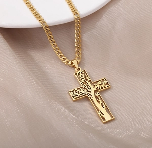 Gros plan du pendentif croix arbre de vie doré sur soie avec une chaîne cubaine