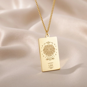 Detalle macro del collar zodiaco Leo bañado en oro de 18K con grabado de tótem y estrellas