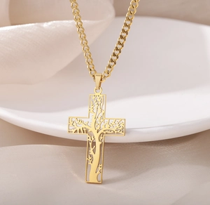 Détail du pendentif croix dorée en acier inoxydable avec motif arbre de vie découpé
