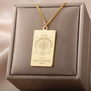 Vista macro del collar con colgante de tarot Sagitario en oro de 18K sobre joyero
