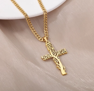 Gros plan du pendentif croix Arbre de Vie doré sur une chaîne cubaine sur soie