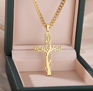 Pendentif croix arbre de vie doré et chaîne cubaine dans un écrin à bijoux vert de luxe
