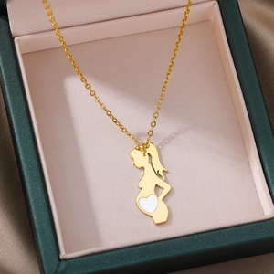 Detailed view of a gold pregnant silhouette pendant with a white heart in a gift box