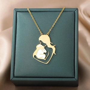 Detail of gold mother and child necklace with white enamel on silk background