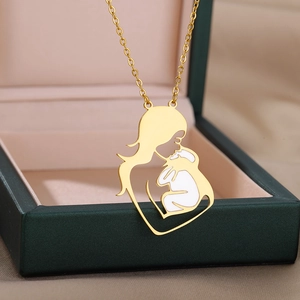 Detailed close-up of a gold mother and baby silhouette pendant with white enamel inlay