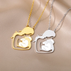 Close-up of mother and child silhouette pendant necklaces on elegant champagne satin fabric