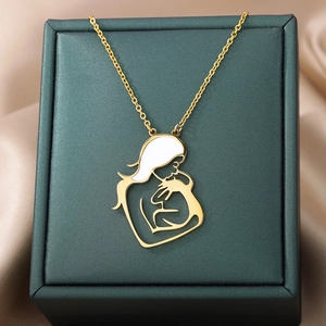 Close-up of golden mother and child pendant on green jewelry box for Mother's Day