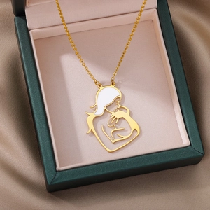 Close-up of mother and child silhouette pendant in gold and white enamel in a jewelry box