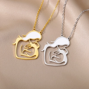 Detailed close-up of gold and silver mother and child pendants on silk fabric