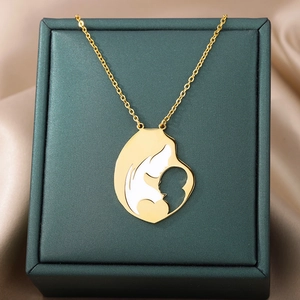 Detail of a golden mother and baby silhouette pendant on green leather jewelry box