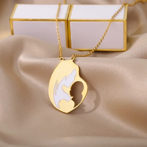 Macro view of gold mother and baby silhouette necklace on elegant champagne satin