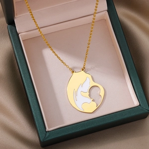 Detail of a golden mother and child pendant in a premium dark green jewelry gift box