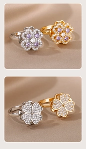 Makro-Detail von drehbaren Kleeblatt-Ringen in Silber und Gold mit lila Zirkonia-Steinen