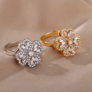 Rotating zircon flower rings in silver and gold plating on premium satin fabric