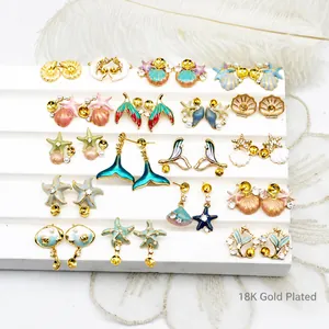 Detail of 18K gold plated starfish and shell earrings with pearls and colorful enamel