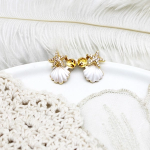 Detailed close-up of ocean-style starfish and shell earrings with gold plating and zircons