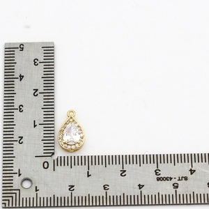 18K gold plated brass teardrop pendant with zircon stones measured against a ruler