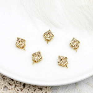 Dettaglio di cinque ganci a corona placcati oro 18K con zirconi per creazione gioielli fai-da-te