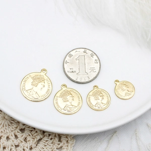 Detailed macro view of 18K gold-plated queen coin pendants in four different sizes