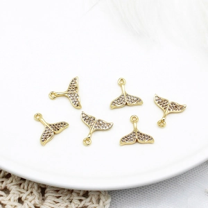 Detailed view of six gold-plated fish tail charms with micro-pave cubic zirconia stones