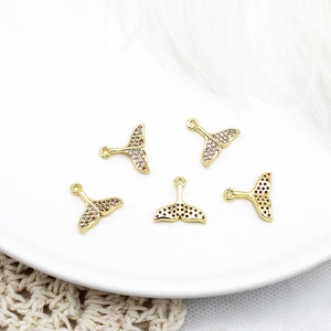 Detailed view of 18K gold plated fish tail pendants with micro-set zircon for DIY jewelry