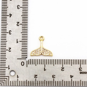 18K gold plated whale tail charm with zircon stones shown with measuring scale