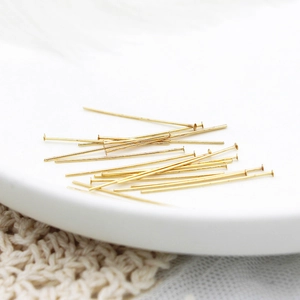 Dettaglio di spilli a testa piatta placcati oro 18K su vassoio per creazione gioielli