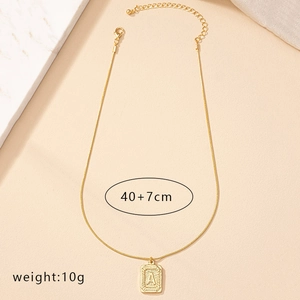Golden necklace detail showing A-letter square pendant with sunburst texture and 40cm chain