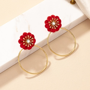 Detail of vintage burgundy flower earrings with a central diamond on marble and silk