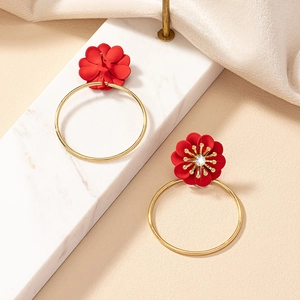 Detail view of burgundy flower hoop earrings with crystal center and gold needles